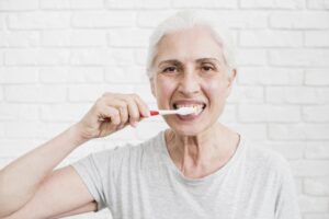 elder woman washing her teeth