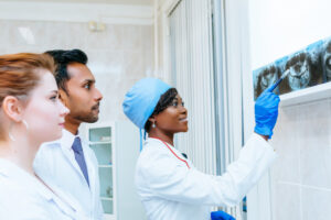 multiracial-dental-team-checking-teeth-x-ray-patient-dental-clinic-concept_132024-713