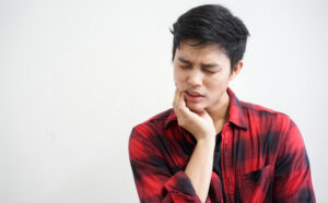 man-using-hand-cover-cheek-relief-pain-from-wisdom-tooth